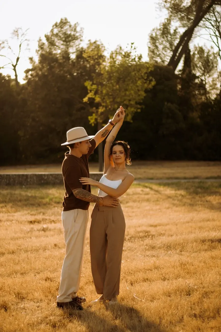 Un couple danse dans un champ doré, au coucher du soleil